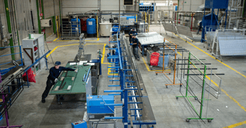 Vista di uno stabilimento di lavorazione del vetro con i suoi macchinari e le sue linee di produzione, nel contesto dell'implementazione di un nuovo ERP.