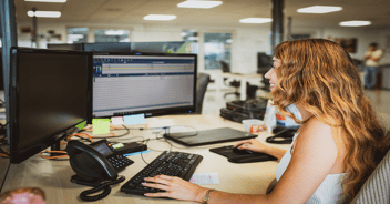 Impiegata che inserisce un ordine del cliente nel software ERP dalla sua postazione di lavoro.