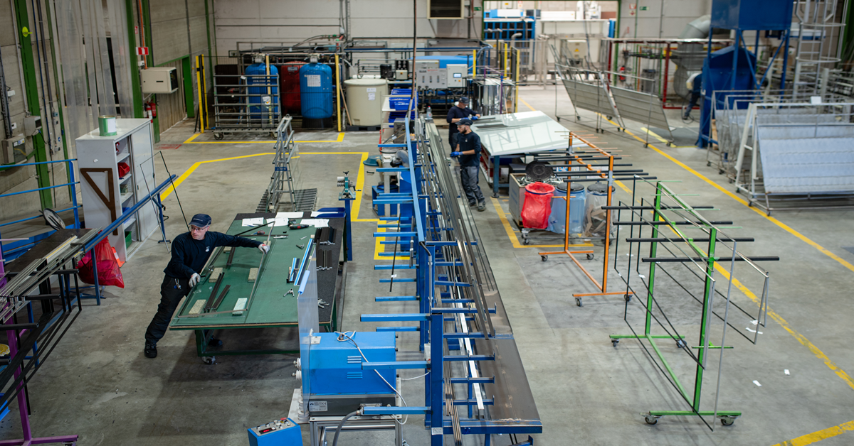 Vista di uno stabilimento di lavorazione del vetro con i suoi macchinari e le sue linee di produzione, nel contesto dell'implementazione di un nuovo ERP.