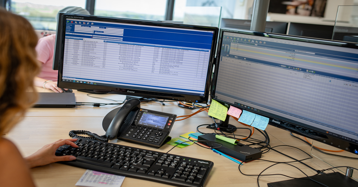 Postazione di lavoro con due schermi affiancati che visualizzano l'interfaccia del software ERP utilizzato in un contesto professionale.