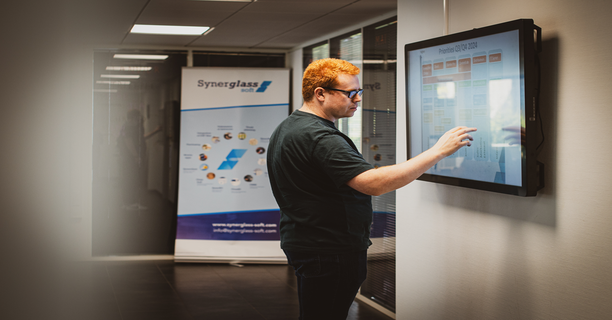 Dipendente che utilizza un touch screen interattivo situato all'ingresso dell'azienda per accedere alle informazioni.